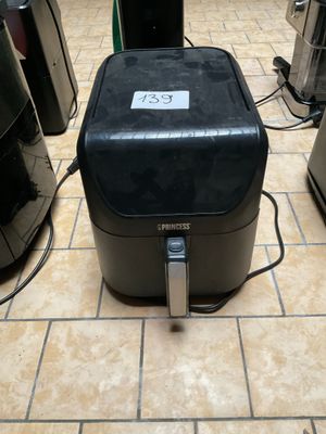 un grille-pain noir posé par terre à côté d'un four grille-pain