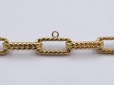 a close up of a gold chain on a white surface