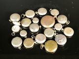 a close up of a bunch of silver and gold charms on a black surface