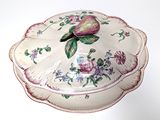 a white plate with a flower on it on a table