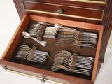 a wooden box filled with silverware on a white surface