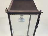 an old fashioned lantern with a light bulb on a white background