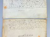 two old papers with writing on them sitting on a table