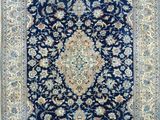 a blue and beige rug with a medallion design on it
