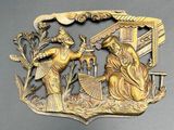 brass plate depicting a scene of a man and a woman in a garden