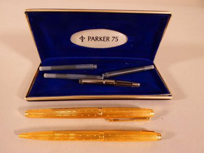 deux stylos et un stylo dans une boîte bleue posée sur une table