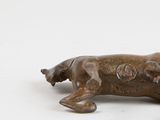 a bronze statue of a dog laying down on its back