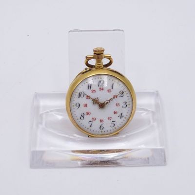 une petite montre de poche en or présentée dans un coffret transparent