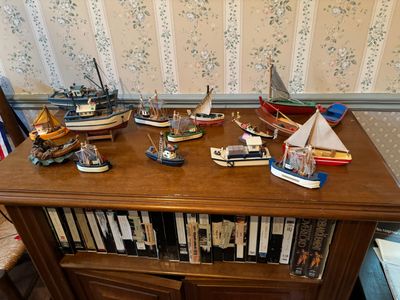une étagère sur laquelle sont posés plusieurs bateaux miniatures