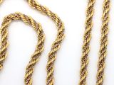 two pieces of gold rope on a white surface
