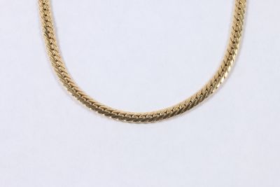 gros plan d'un collier en chaîne en or sur fond blanc