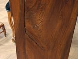 a wooden cabinet with a marble top on a hard wood floor