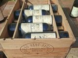 several bottles of wine are in a wooden box on a table