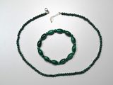 collier et bracelet composés de perles de verre vertes sur un fond blanc