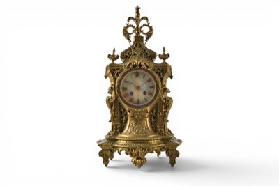 a gold clock that is sitting on a stand