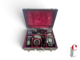 an open suitcase with a camera and other items in it