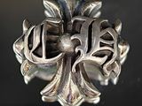 une bague en argent ornée d'une croix, posée sur une table