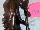a bronze statue of a woman with a bird on her head