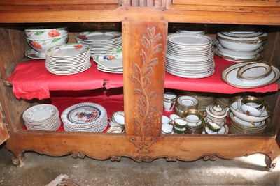 a wooden cabinet with many plates and bowls on it