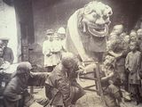 an old photo of a group of people standing around a statue of a lion