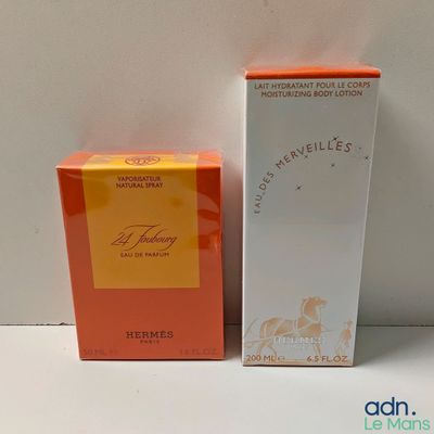 une boîte de parfum orange et blanche à côté d'une boîte de parfum blanche