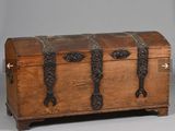 un vieux coffre en bois posé sur une surface grise
