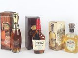 Plusieurs bouteilles d'alcool sont alignées sur une surface blanche