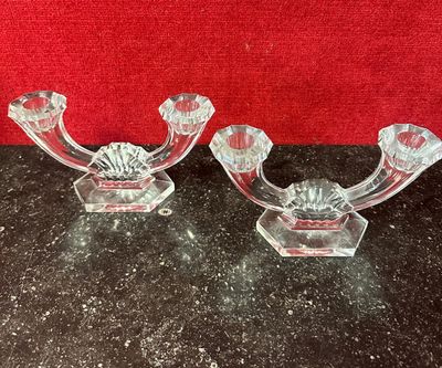 two clear glass candlesticks on a black table