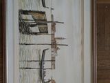 painting of a boat in the water in a frame on a wooden wall