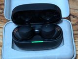 a pair of black earphones in a case on a wooden table