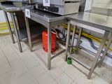 une cuisine avec de nombreux plans de travail en inox et une borne d'incendie rouge