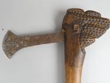 a large wooden axe with a carved head on top of it