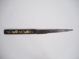 a close up of a knife on a white surface with a black handle