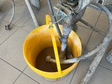a yellow bucket filled with water sitting on a tiled floor