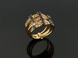 gros plan d'une bague en or avec des pierres multicolores