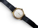 une image d'un gros plan d'une montre-bracelet sur une surface blanche