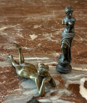 une statue représentant une femme allongée par terre à côté d'une statue représentant un homme