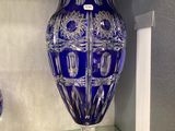 a blue vase sitting on a glass shelf in a room