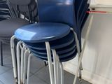 four blue chairs in a room with a white board
