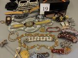 several pairs of glasses, bracelets, and other jewelry are on a table