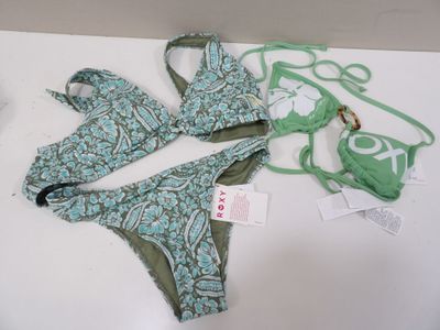 a green bikini and a green bra top on a white table