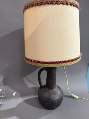 une lampe posée sur une table à côté d'un vase