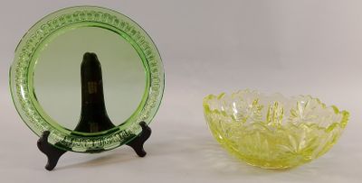 un bol en verre vert à côté d'une assiette en verre jaune