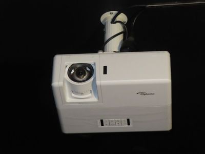 a camera attached to a wall mounted projector