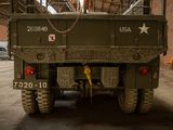 a military truck parked inside of a building with a chain on the back of it