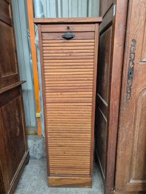 une grande armoire en bois dont la porte est ouverte, dans une pièce