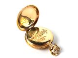 a gold pocket watch sitting on a white surface
