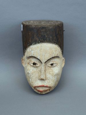 une image représentant un masque en bois au visage blanc et aux cheveux bruns