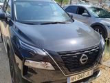 a black nissan suv parked in a parking lot next to other cars