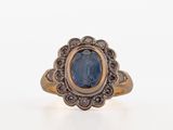 a close up of a ring with a blue stone in it